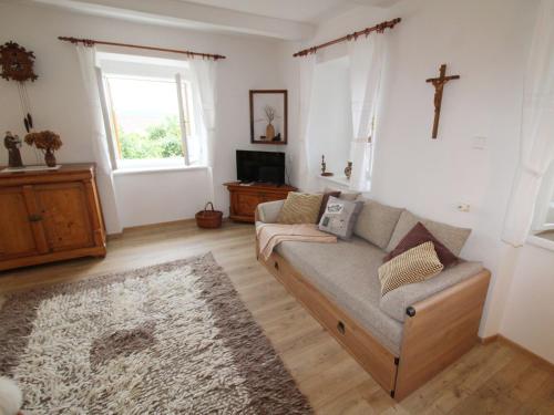 a living room with a couch and a cross on the wall at Holiday Home Libel by Interhome in Libel