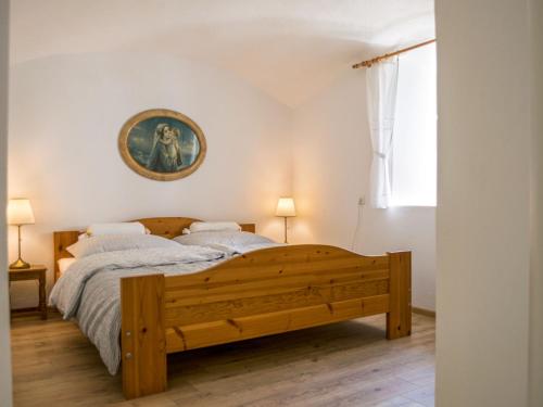 a bedroom with a wooden bed and a picture on the wall at Holiday Home Libel by Interhome in Libel
