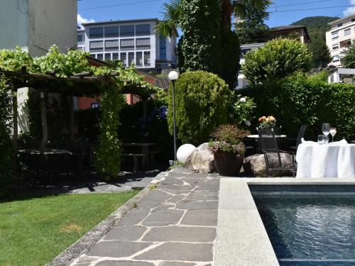 a backyard with a swimming pool and a table and chairs at Studio Capriccio 15 Studio Balcony by Interhome in Intragna