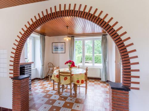 łuk w pokoju ze stołem i kominkiem w obiekcie Holiday Home Le Bois Bourdin by Interhome w mieście Pontorson