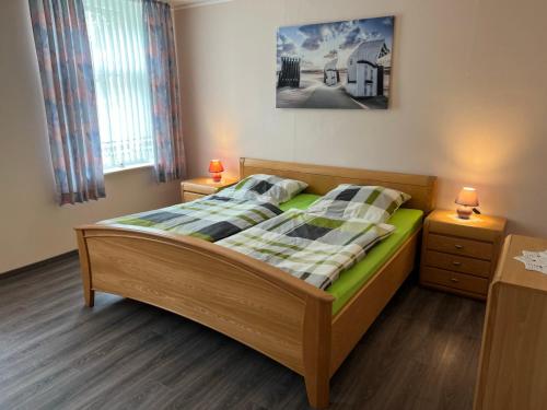 a bedroom with a bed and two night stands at Holiday Home Kettler by Interhome in Weener