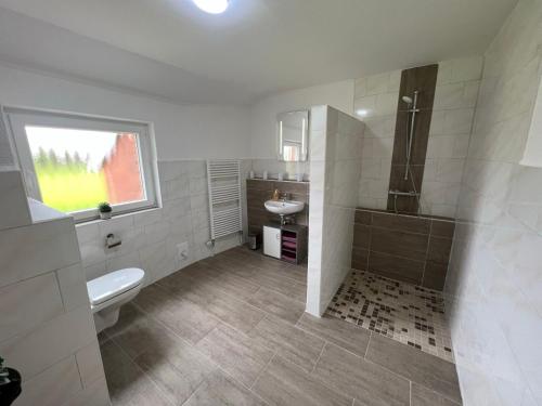a white bathroom with a toilet and a sink at Holiday Home Kettler by Interhome in Weener
