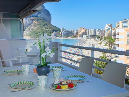 een tafel met eten en uitzicht op het strand bij Apartment Esmeralda-4 by Interhome in Calpe