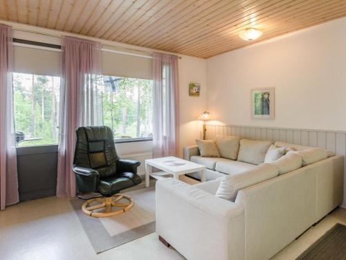 uma sala de estar com um sofá e uma cadeira em Holiday Home Loma-koli 6 by Interhome em Hattusaari