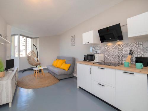 uma cozinha e sala de estar com um sofá e um micro-ondas em Apartment Hernando I by Interhome em Calpe