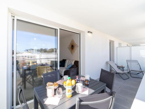 un salon avec une table et des chaises et un balcon dans l'établissement Apartment Passage Saint-Clément by Interhome, à Quiberon