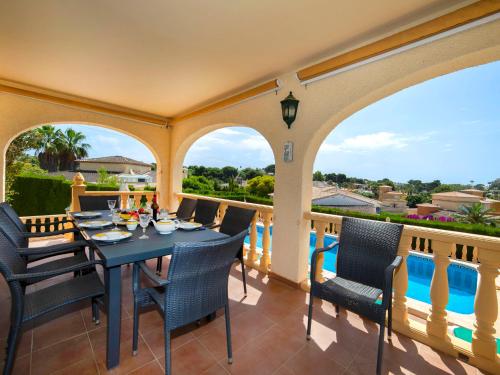 taras ze stołem i krzesłami na balkonie w obiekcie Holiday Home Marie Louise by Interhome w mieście Calpe