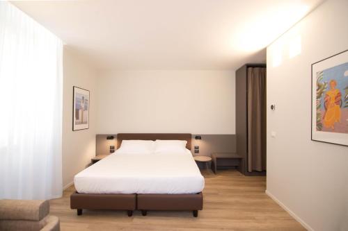a bedroom with a white bed and a chair at Palazzo Bellocchi - Suites & Apartments in Brindisi