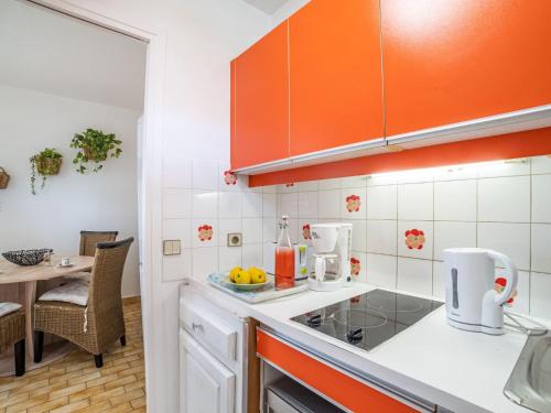 - une cuisine avec des appareils orange et blancs et une table dans l'établissement Studio LE BAHIA by Interhome, à Villeneuve-Loubet