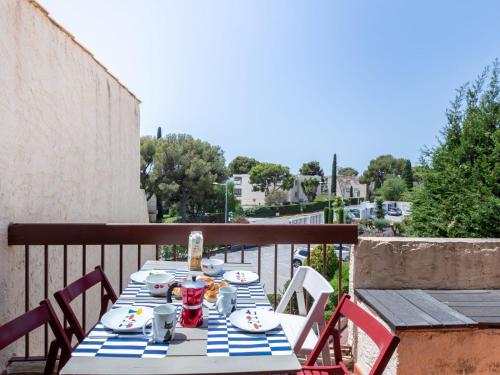 une table avec des assiettes de nourriture sur un balcon dans l'établissement Apartment Les Cyprès by Interhome, à Bandol
