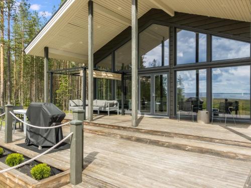 a glass house with a tv on a wooden deck at Holiday Home Merilänranta by Interhome in Manamansalo