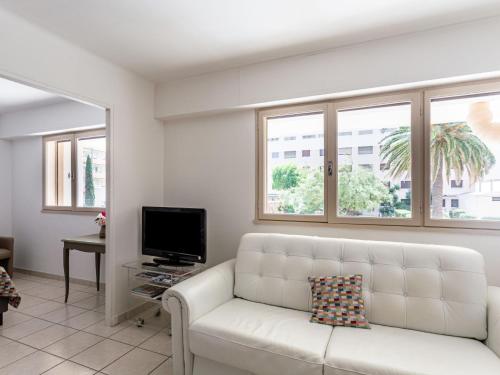 - un salon avec un canapé blanc et des fenêtres dans l'établissement Studio Le Grand Large-5 by Interhome, au Lavandou