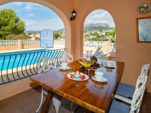 a table and chairs on a balcony with a pool at Holiday Home Marisol Park by Interhome in Calpe