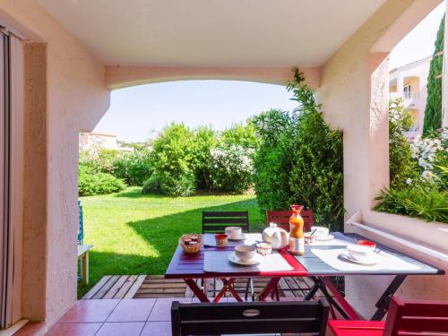 - une table sur une terrasse avec vue sur la cour dans l'établissement Apartment Domaine VarAzur by Interhome, aux Issambres