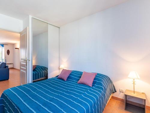 une chambre avec un lit bleu et un miroir dans l'établissement Apartment Terre du Soleil-1 by Interhome, à Sainte-Maxime