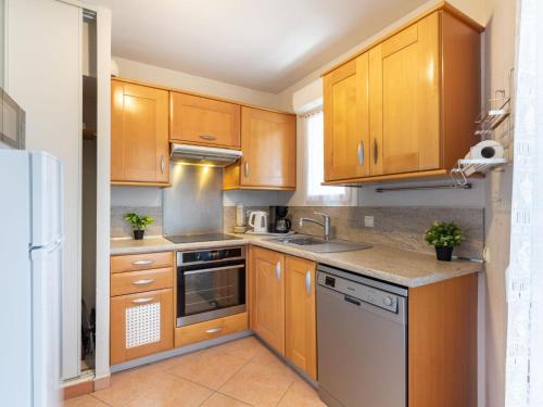 une cuisine avec des armoires en bois et des appareils en acier inoxydable dans l'établissement Apartment Terre du Soleil-1 by Interhome, à Sainte-Maxime