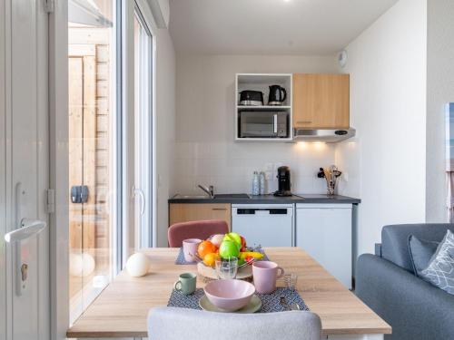 a living room with a table with a bowl of fruit at Apartment SC H01 by Interhome in Mimizan