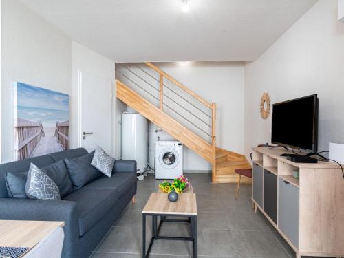 un salon avec un canapé et une télévision dans l'établissement Apartment SC H01 by Interhome, à Mimizan