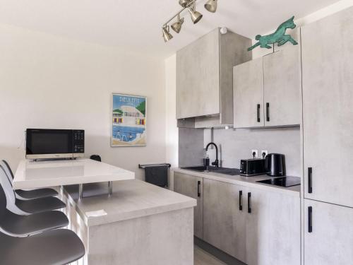 une cuisine avec des placards blancs, une table et un bureau dans l'établissement Apartment Cimiez Les Pins by Interhome, à Nice