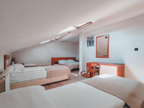 a hotel room with two beds and a desk at Motel Almy in Zenica