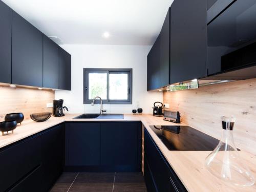 - une cuisine avec des placards noirs et un évier dans l'établissement Holiday Home Le Rahic by Interhome, à Carnac