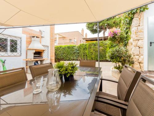 un patio al aire libre con mesa de cristal y sillas en Holiday Home Cantamar by Interhome, en Torredembarra