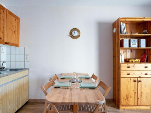 une cuisine avec une table en bois, des chaises et une horloge dans l'établissement Studio Joséphine-1 by Interhome, à Arcachon