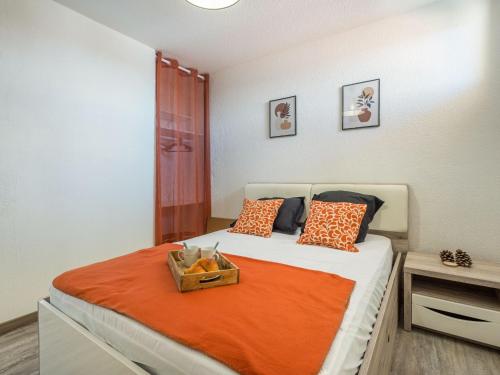 une chambre avec un lit avec une couverture orange dans l'établissement Apartment Babel by Interhome, à Canet