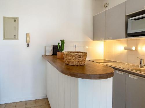 a kitchen with white cabinets and a wooden counter top at Apartment Saint James-13 by Interhome in Le Lavandou