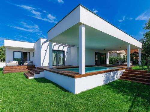 a white house with a swimming pool and grass at Holiday Home Villa Valle by Interhome in Bale
