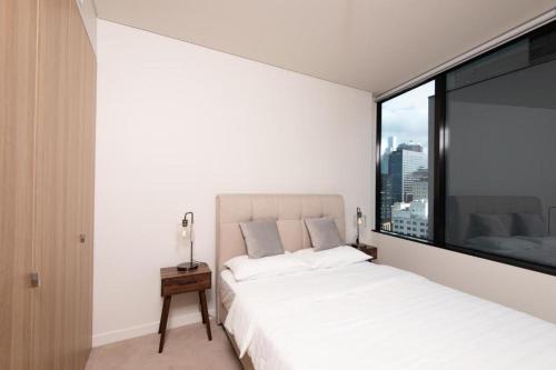 a bedroom with a white bed and a large window at MetaWise Sydney CBD Luxury City view 2BED Apartment in Sydney