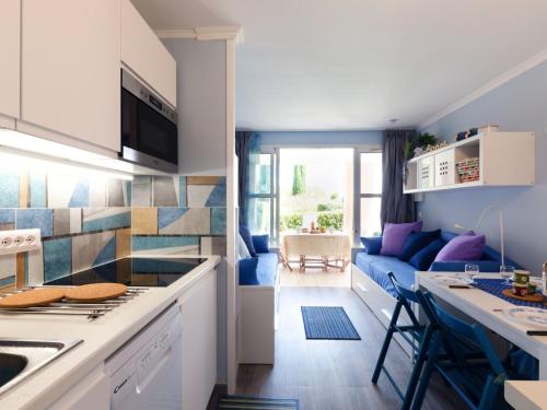 Il comprend une cuisine et un salon doté d'un canapé bleu. dans l'établissement Apartment L'Esquinade - F6 019 by Interhome, à Saint-Raphaël