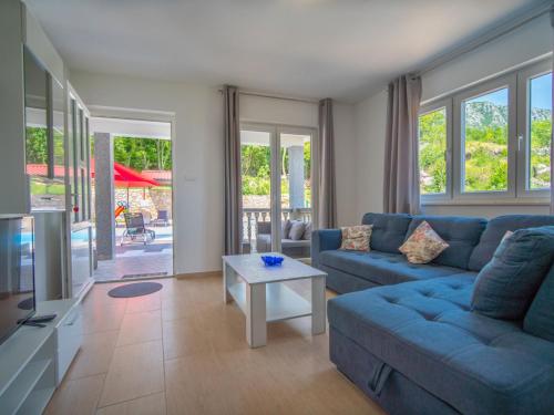 a living room with a blue couch and a table at Holiday Home Olivia by Interhome in Bribir