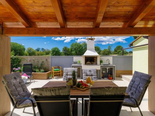 a patio with a table and chairs and a fireplace at Holiday Home Laura in Pula