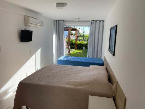ein kleines Schlafzimmer mit zwei Betten und einem Fenster in der Unterkunft Paraiso dos Corais in Guarajuba