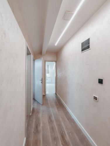 an empty room with white walls and wooden floors at Motel Almy in Zenica