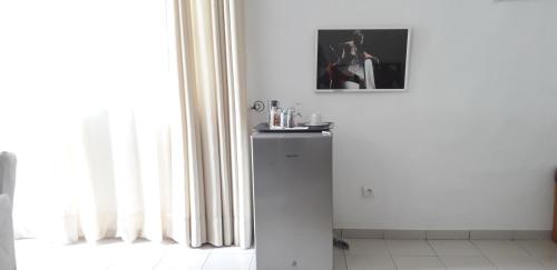 Camera bianca con frigorifero accanto a una finestra. di L'Epicurien a Cotonou