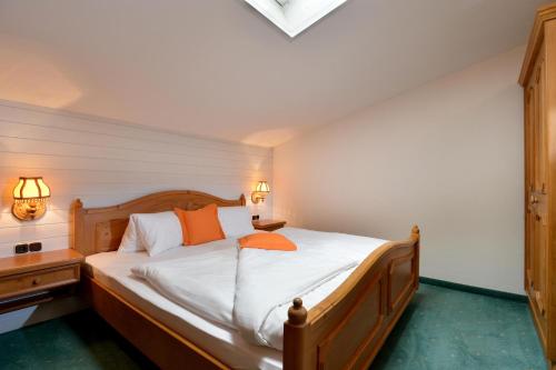 a bedroom with a bed with orange pillows on it at Alpenresidenz Unterrainer in Ellmau