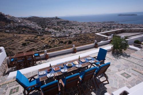 - Balcón con vistas, mesa de comedor y sillas en ERMOUPOLIS PANORAMA ART VILLA, en Ermoupoli