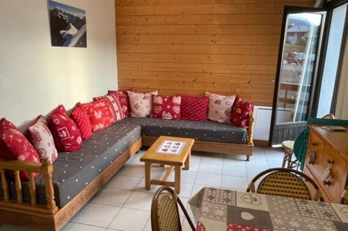 a living room with a couch with red pillows at Charming Apt With Balcony In La Plagne Montalbert in La Plagne