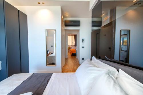 a bedroom with a large white bed and a hallway at Hibrido Boutique Hotel & Spa in Sciacca