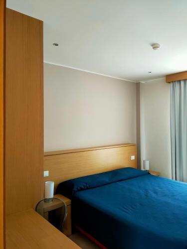 Un dormitorio con una cama azul y una ventana. en Mon Rêve Resort, en Taranto