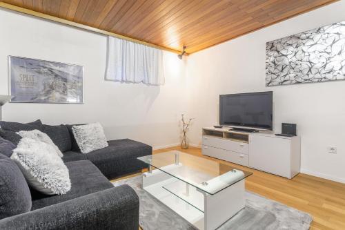 een woonkamer met een bank en een tv bij Viktor apartment in Split