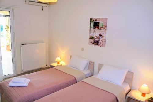 a room with two beds and a picture on the wall at Olive Tree Hillside Apartment in Stalos