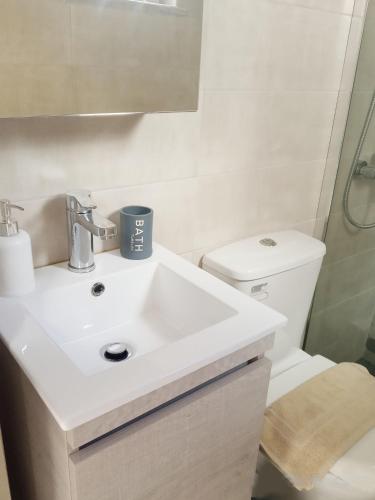 a bathroom with a white sink and a toilet at Studio Victory Chania in Chania