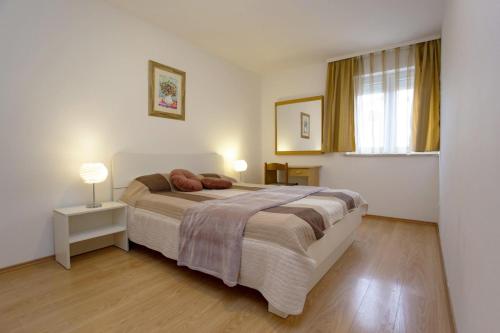 a bedroom with a large bed and a window at Apartments Ulika in Rovinj