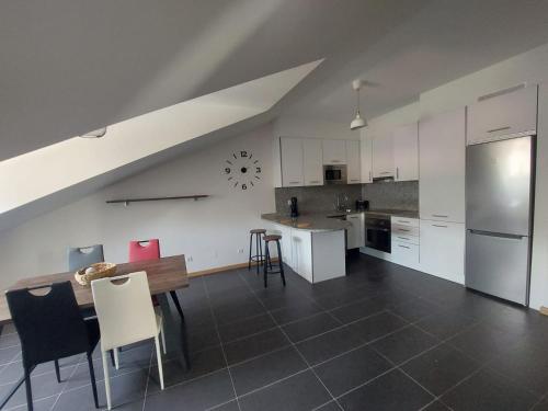 a kitchen with white cabinets and a table and chairs at BRICIA APARTAMENTO 16 in Llanes