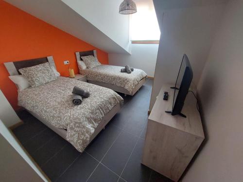 a room with two beds and a television in it at Aldea Bricia 16 in Posada de Llanes