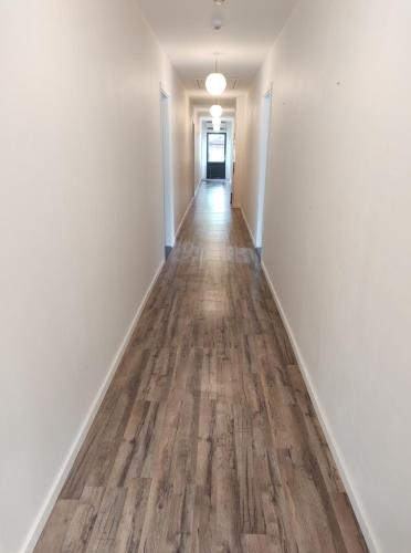 an empty hallway with white walls and wood floors at KragenæsHus in Torrig