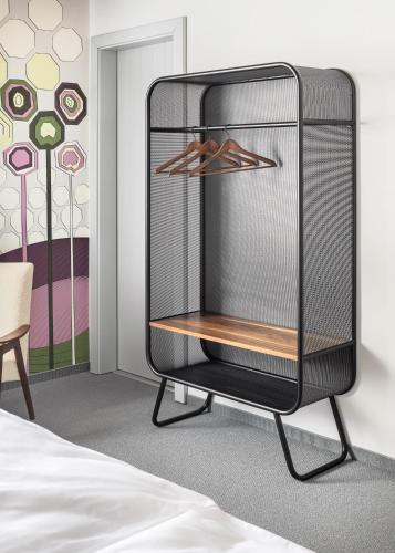 a black wardrobe in a bedroom with a bed at Boutique Hotel Mezi švy in Hradec Králové